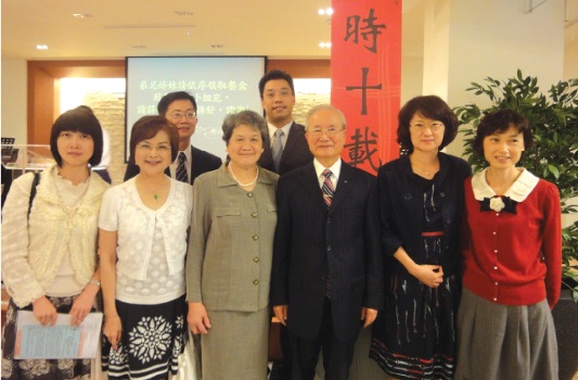 陳傑出校友夫婦（中）、盧理事長（左二）、往高處行作者（右一）、黃牧師（後右一）及母校代表會後合影